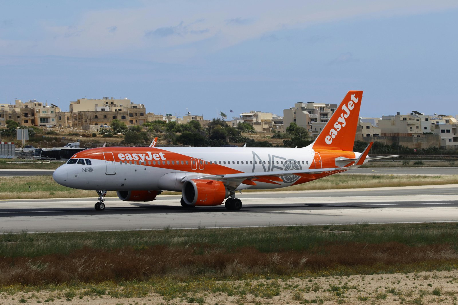 An EasyJet airplane preparing for takeoff on a sunny day at the airport.